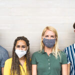 Multiracial friends wearing face mask for preventing and stop co